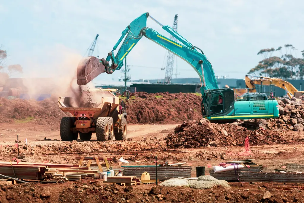Excavator loading soil into a dump truck